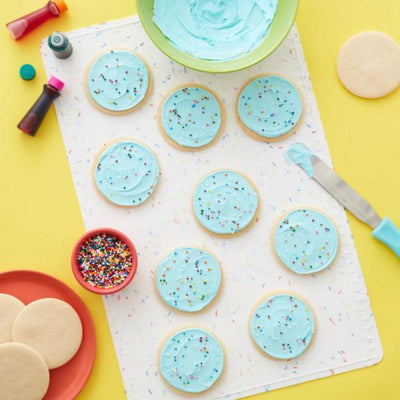 Sugar cookies with icing on confetti fun white silicone baking mat