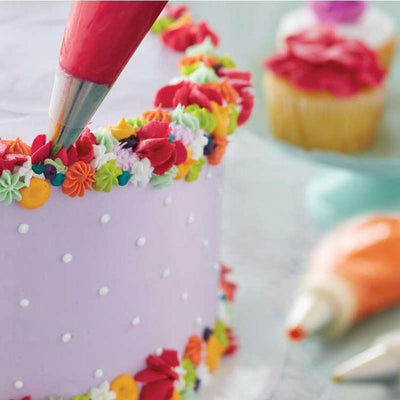 Piping icing decorations onto a cake